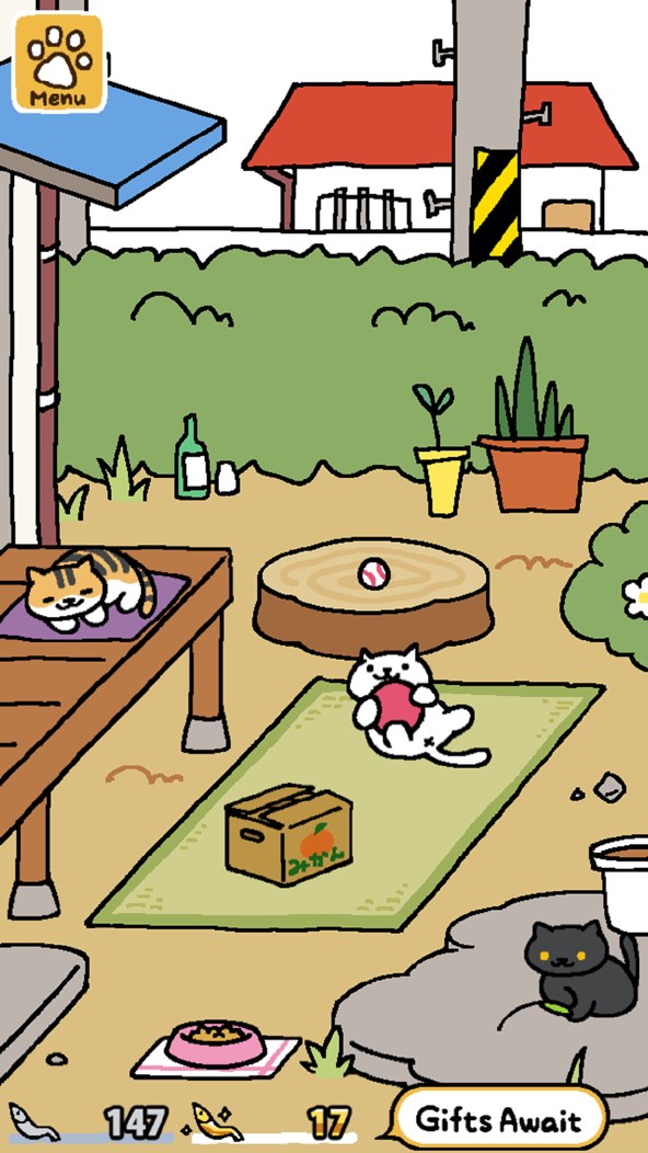 Neko Atsume gameplay screenshot — cute cartoon cats playing in a cozy yard you've set out with toys, a gentle collecting game like Kinder World